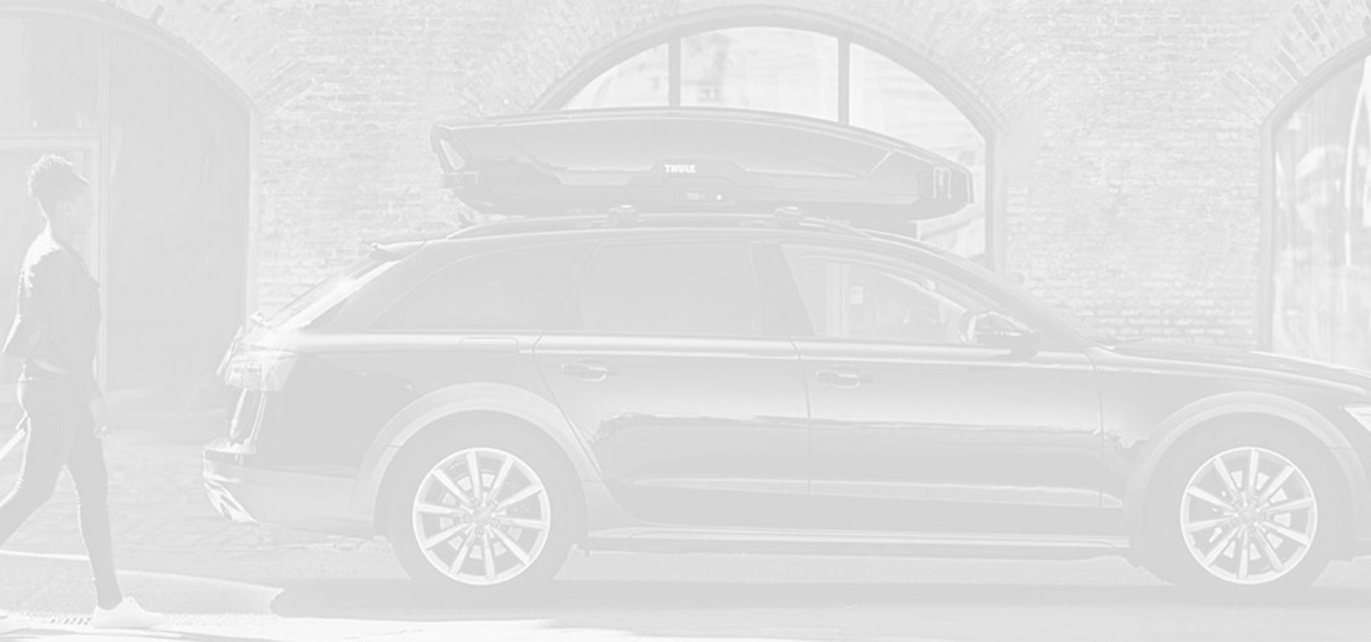 Schwarz-weißes Bild eines Autos mit Dachgepäckträger.